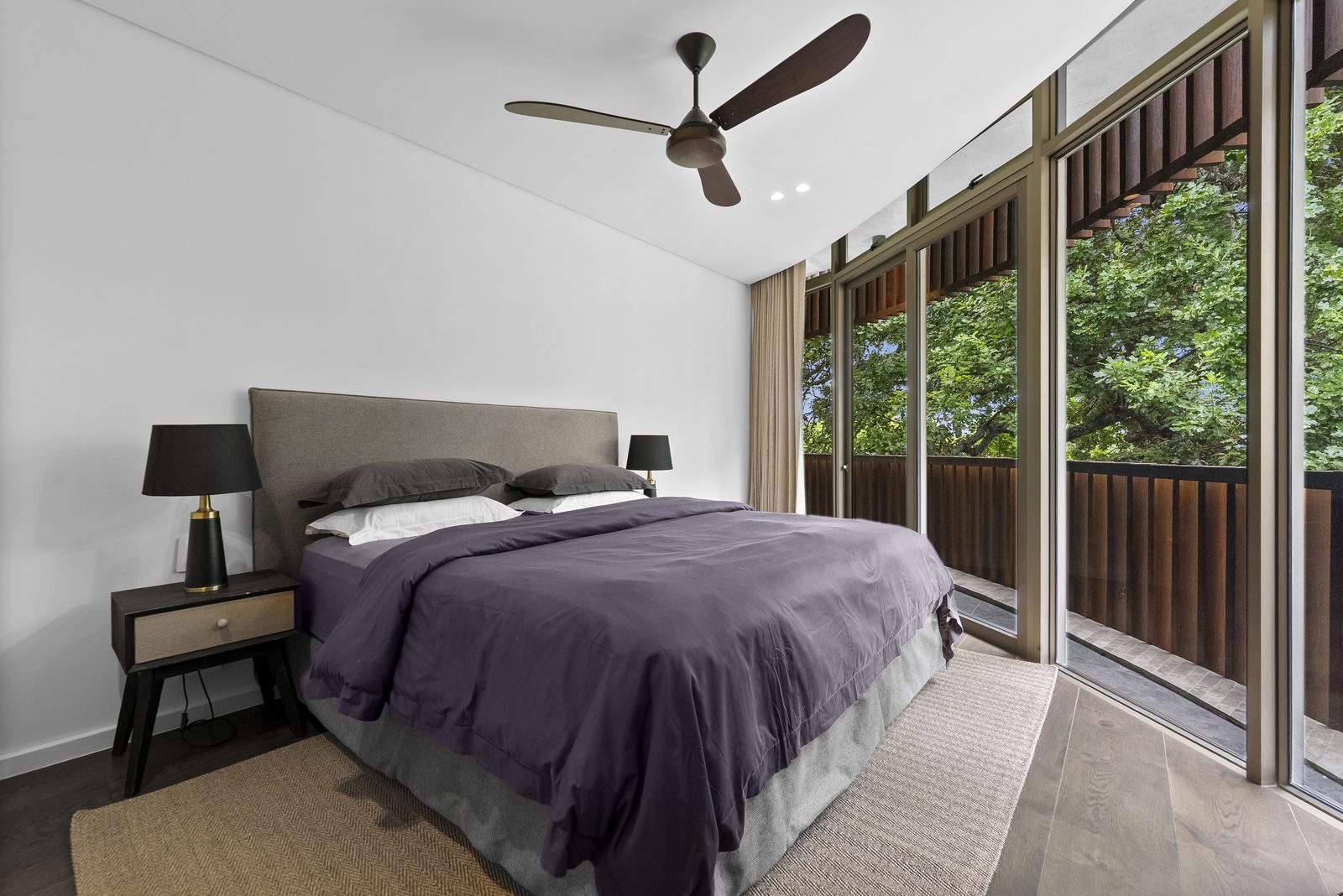 Bedroom four, with floor-to-ceiling glass onto the upstairs balcony